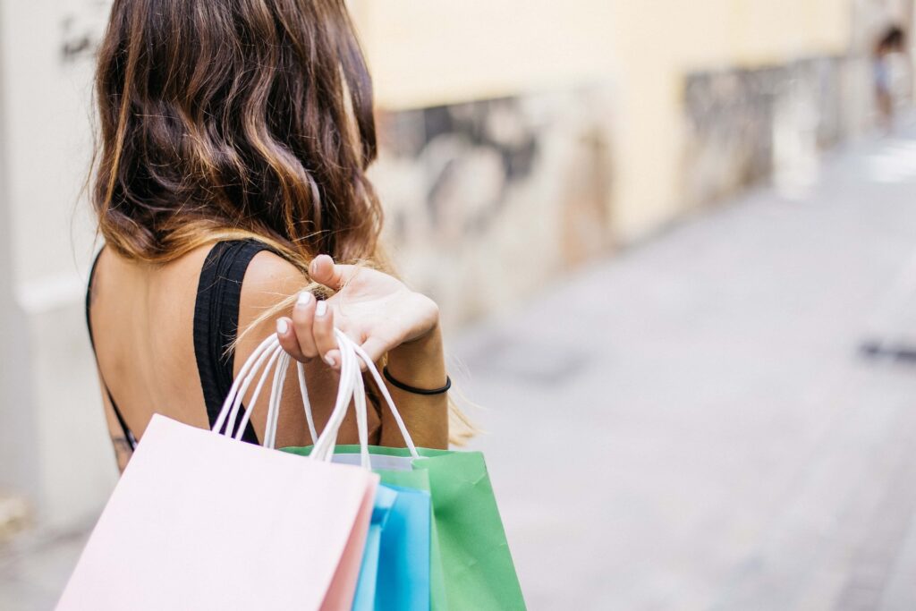 woman holding shopping bags over her shoulder while shopping in Destin in August