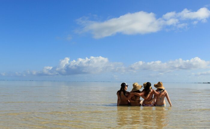 a group sitting on the water at a beach