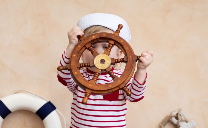 child playing with a mini captain's wheel toy